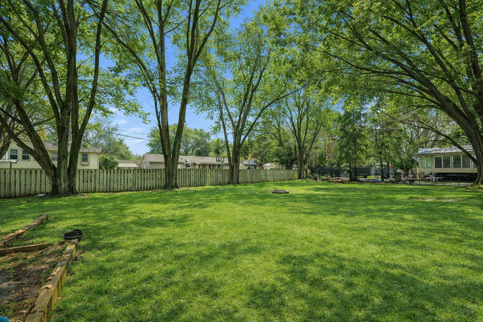 Sunny suburban backyard with trees.png