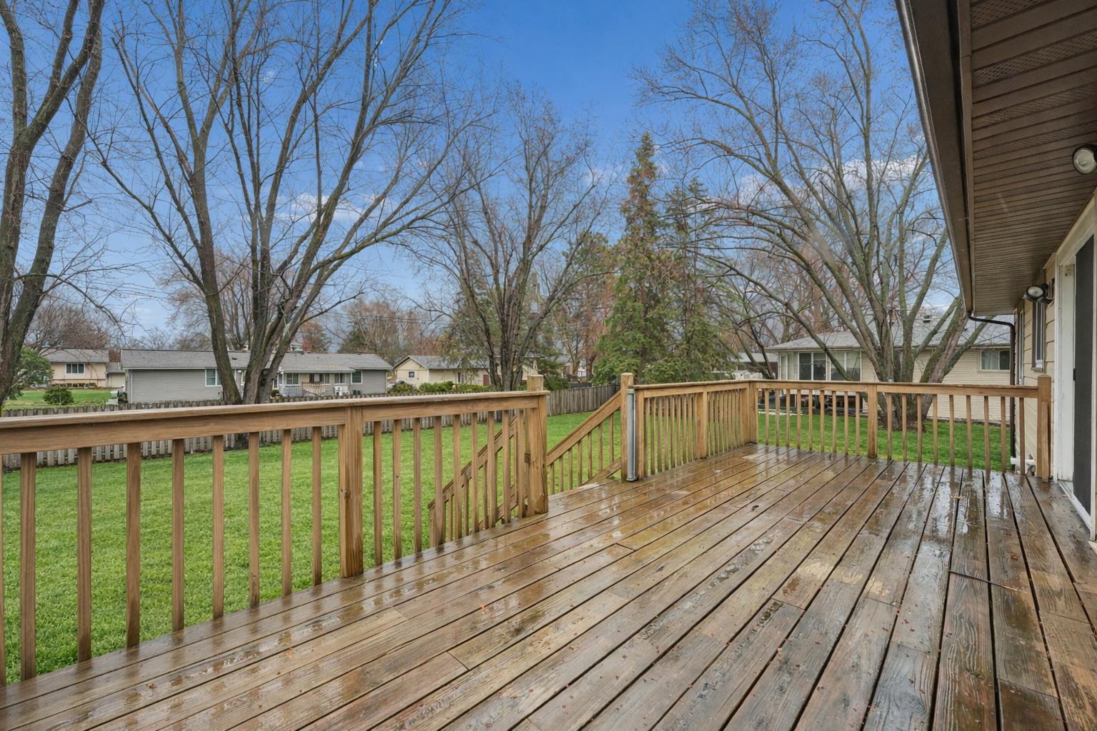 Sunny deck with lush backyard view.png