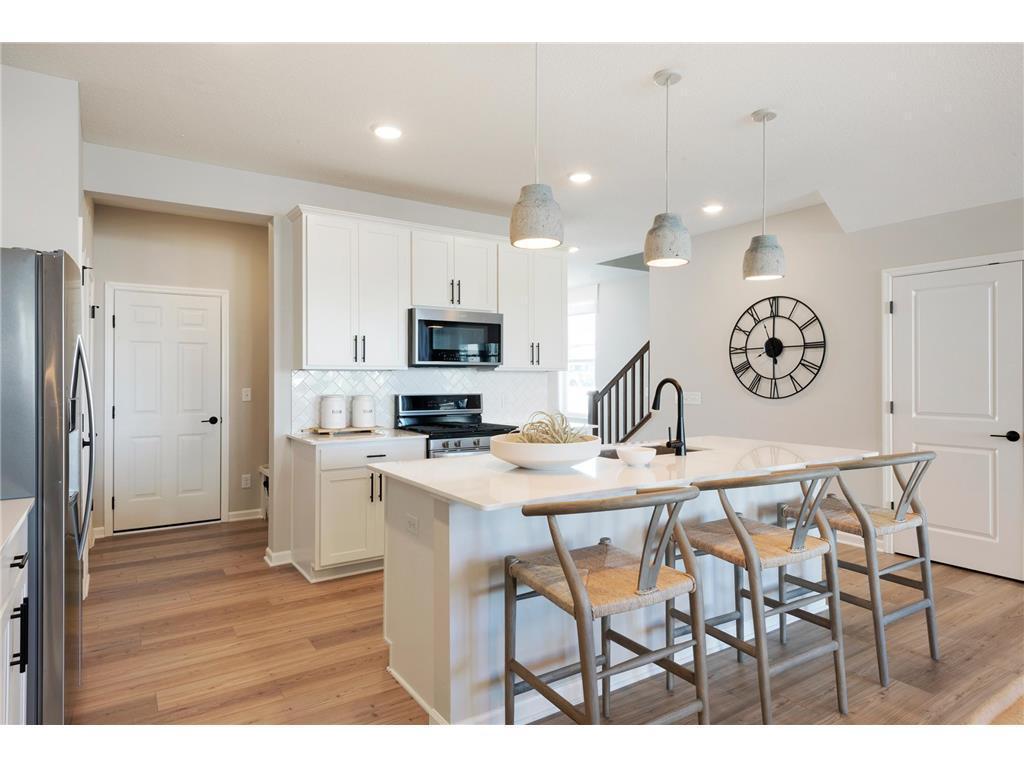 The Ashton's kitchen features a huge island surrounded by even more quartz counters. Durable and beautiful is a great combo! Photo of model home.