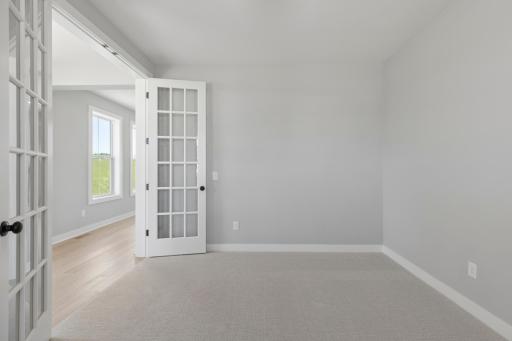Beautiful french doors bring light from foyer windows into main level flex room (photo of actual listing).