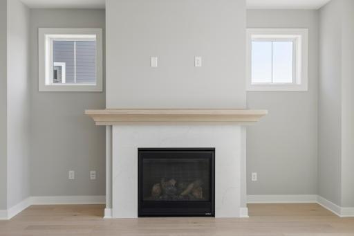 Gas fireplace includes quartz surround and white oak mantel plus tech tube and electrical for future hanging television (photo of actual listing).
