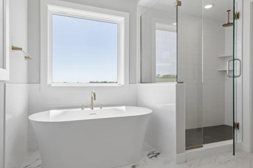 Freestanding tub, ceramic tile floors and walls plus two separate windows in primary bath (photo of actual listing).