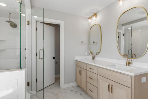 Double sink vanity with quartz countertops, stunning framed mirrors and oak cabinetry (photo of actual listing).