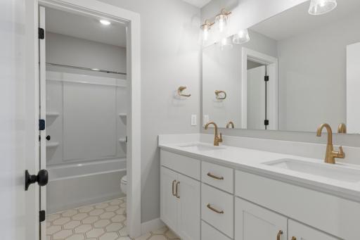 Upstairs hall bath includes double sink vanity and separate room for tub (photo of actual listing).