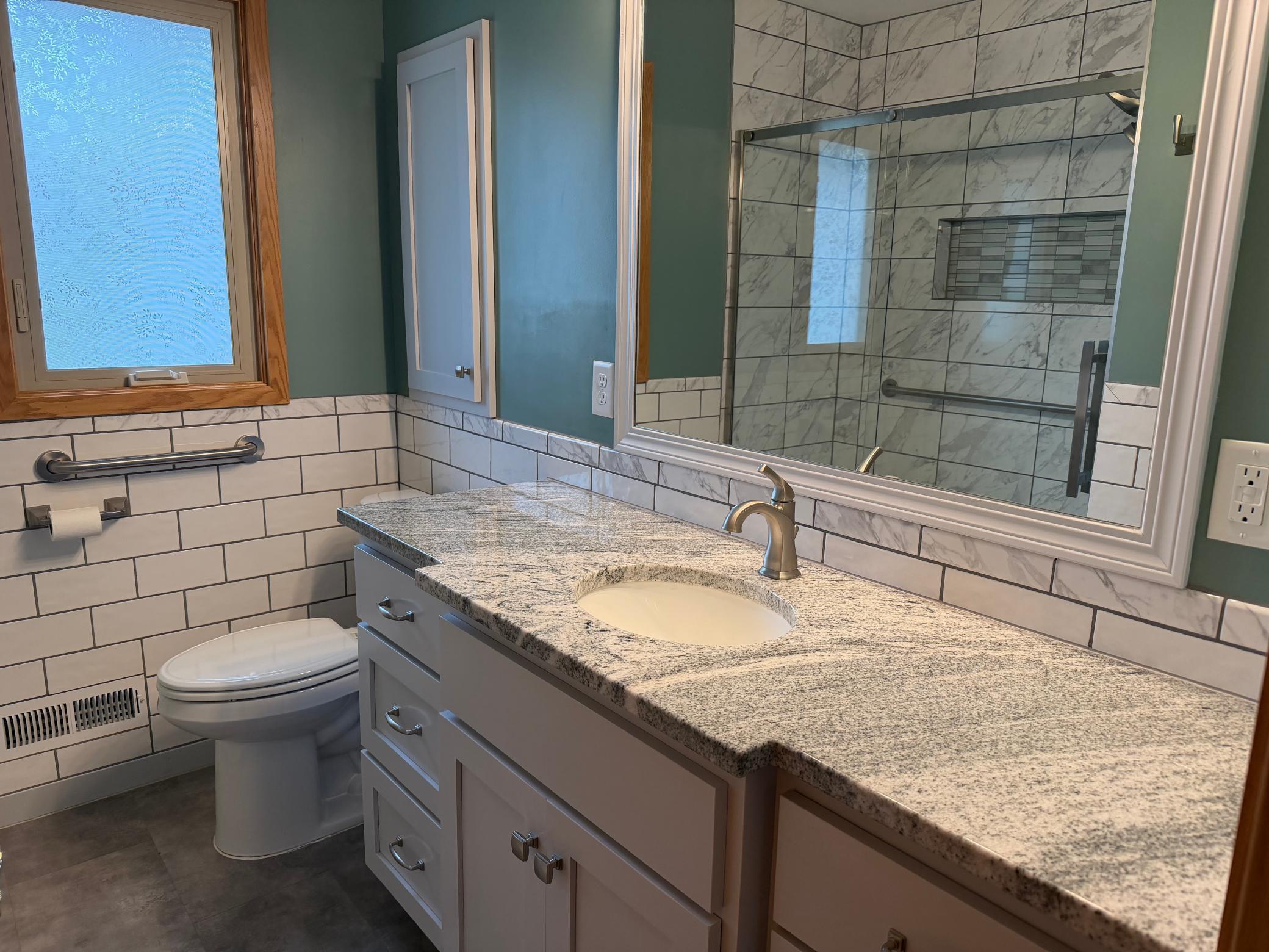 Remodeled bath up with large vanity with granite tops and soft close drawers.