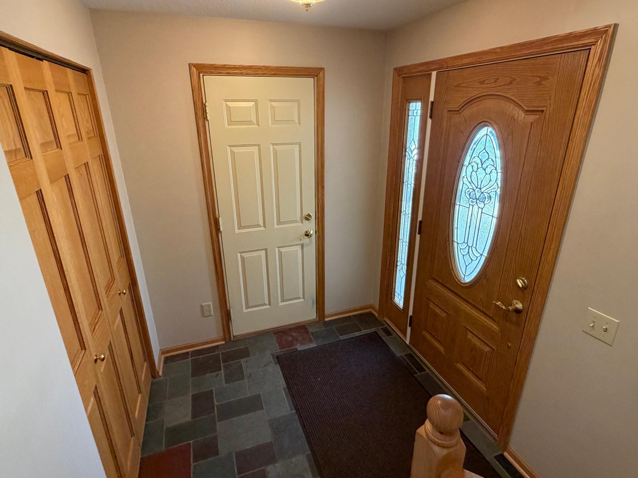 Foyer has a nice sized coat closet and slate tile floor.