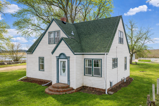 Photo for 10550 New Prague Boulevard, New Prague, MN 56071 - listing #7049236 Front Exterior – Classic White Farmhouse – Expansive Setting1.png