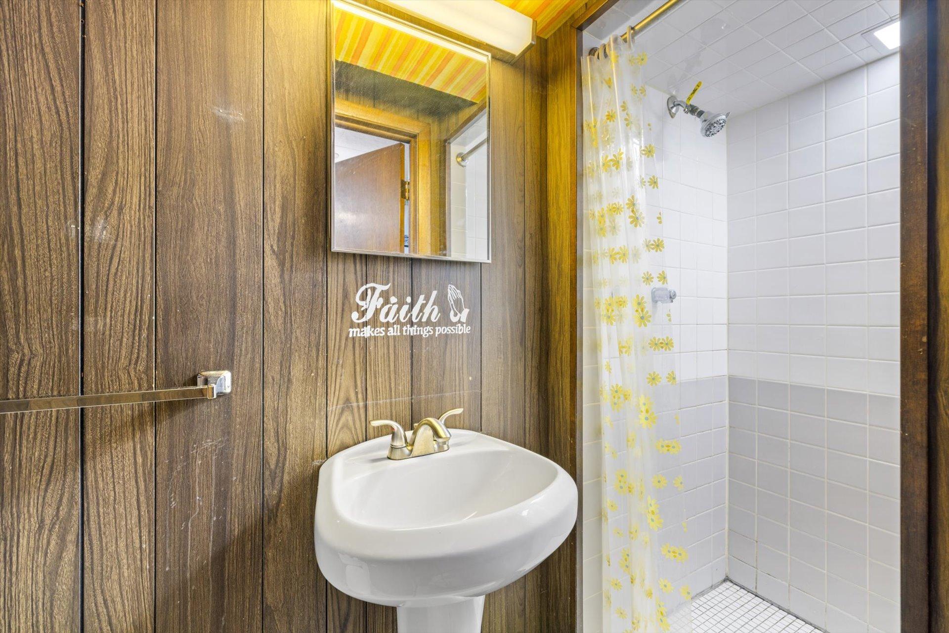 Lower level 3/4 bath with tiled shower, sink and toilet