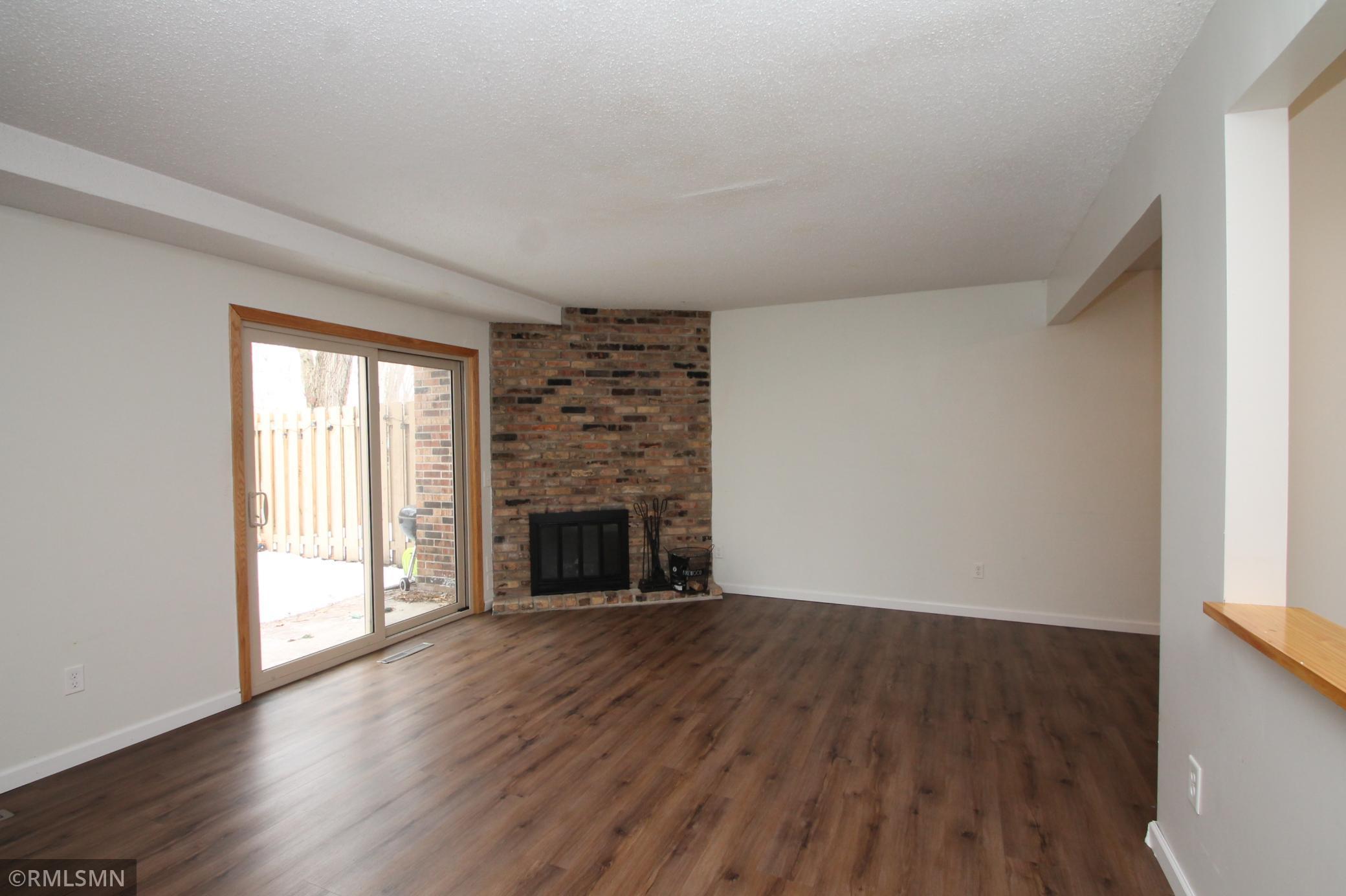 The living room features a wood burning, corner fireplace and sliding doors to patio.