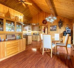 Vaulted, knotty pine beamed ceilings highlight the kitchen & dining room. Sliding doors from the dining room lead to backyard deck overlooking the lake/backyard/beach. Home was designed so that nearly every room has lake/backyard views.
