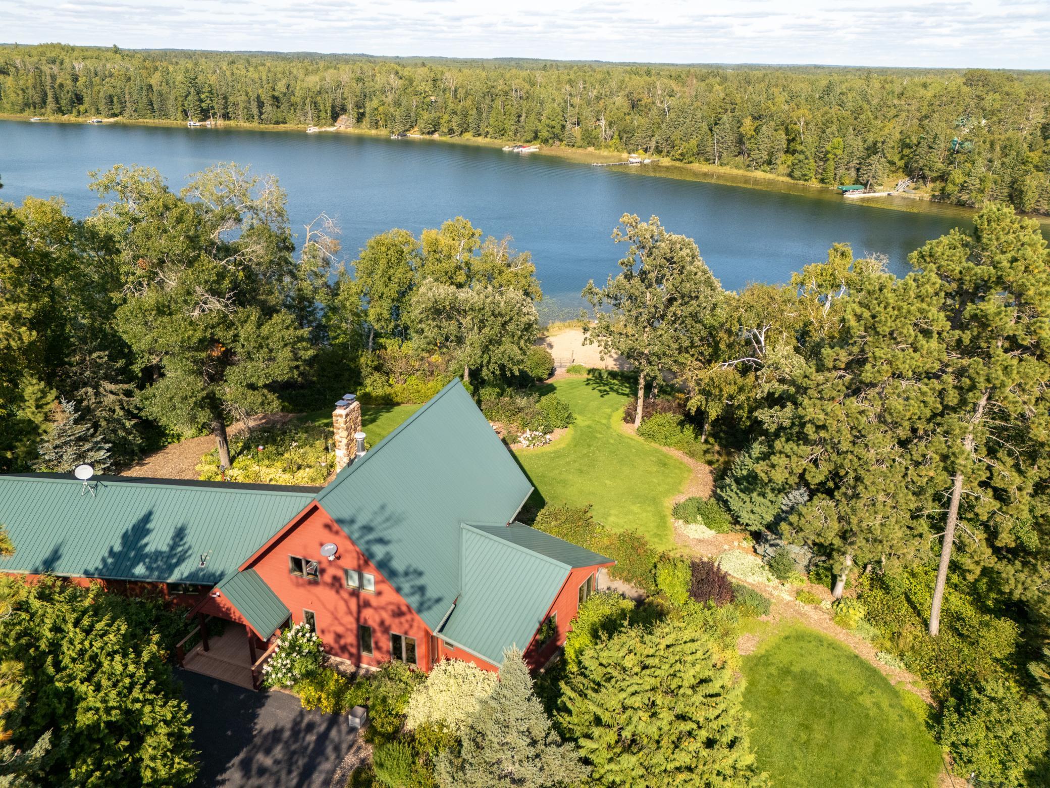 Rare opportunity! Nearly 7 acres positioned on a tip point with panoramic lake views, a level sand beach, and a gated entrance. The extensive landscaping, developed over nearly three decades by horticulturists, creates a fairy tale-like setting.