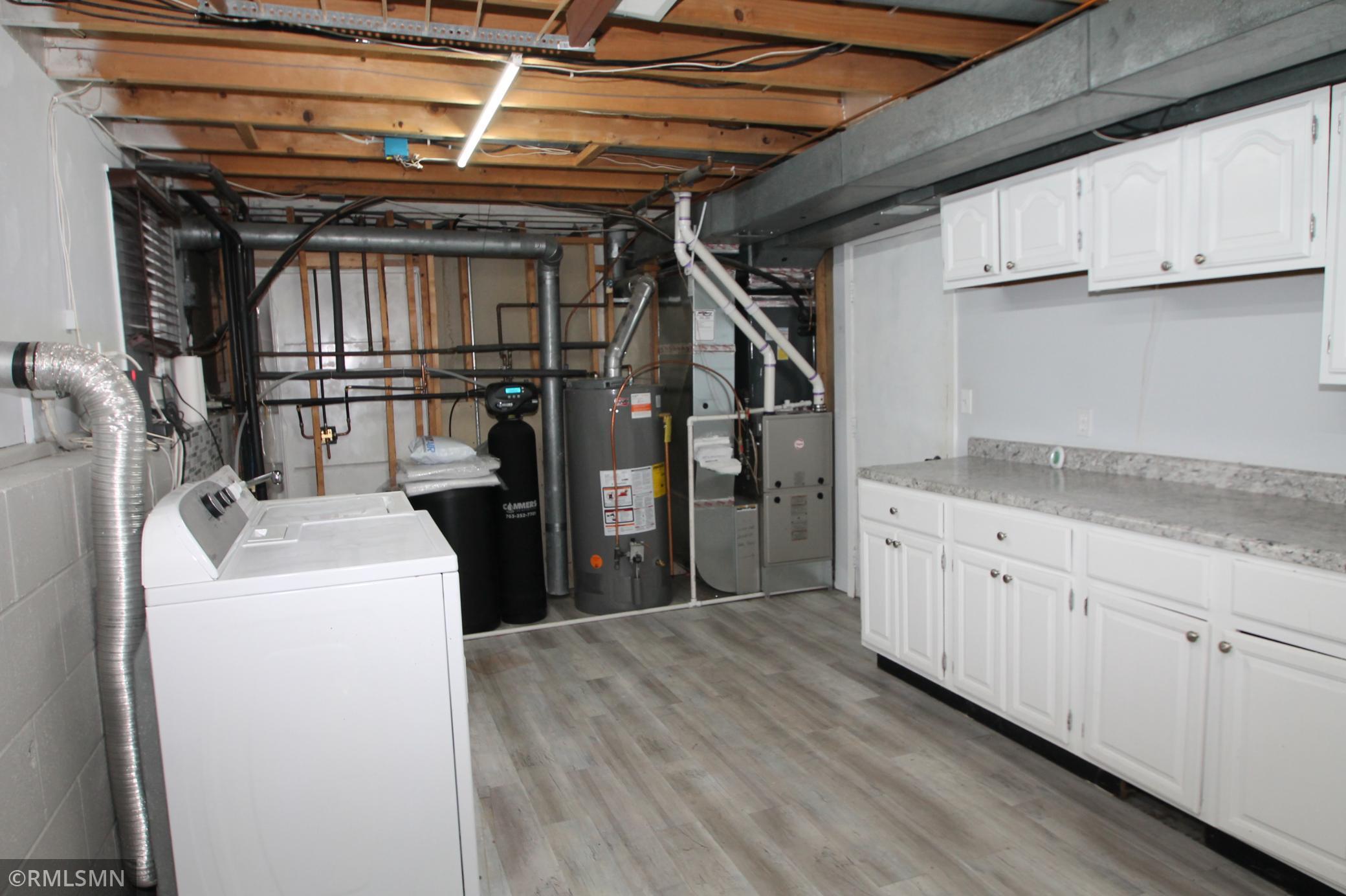 The laundry room has a sink next to the washing machine and extra cabinetry and counterspace making a nice and convenient work area. The furnace, water heater and water softener (owned) are all newer.