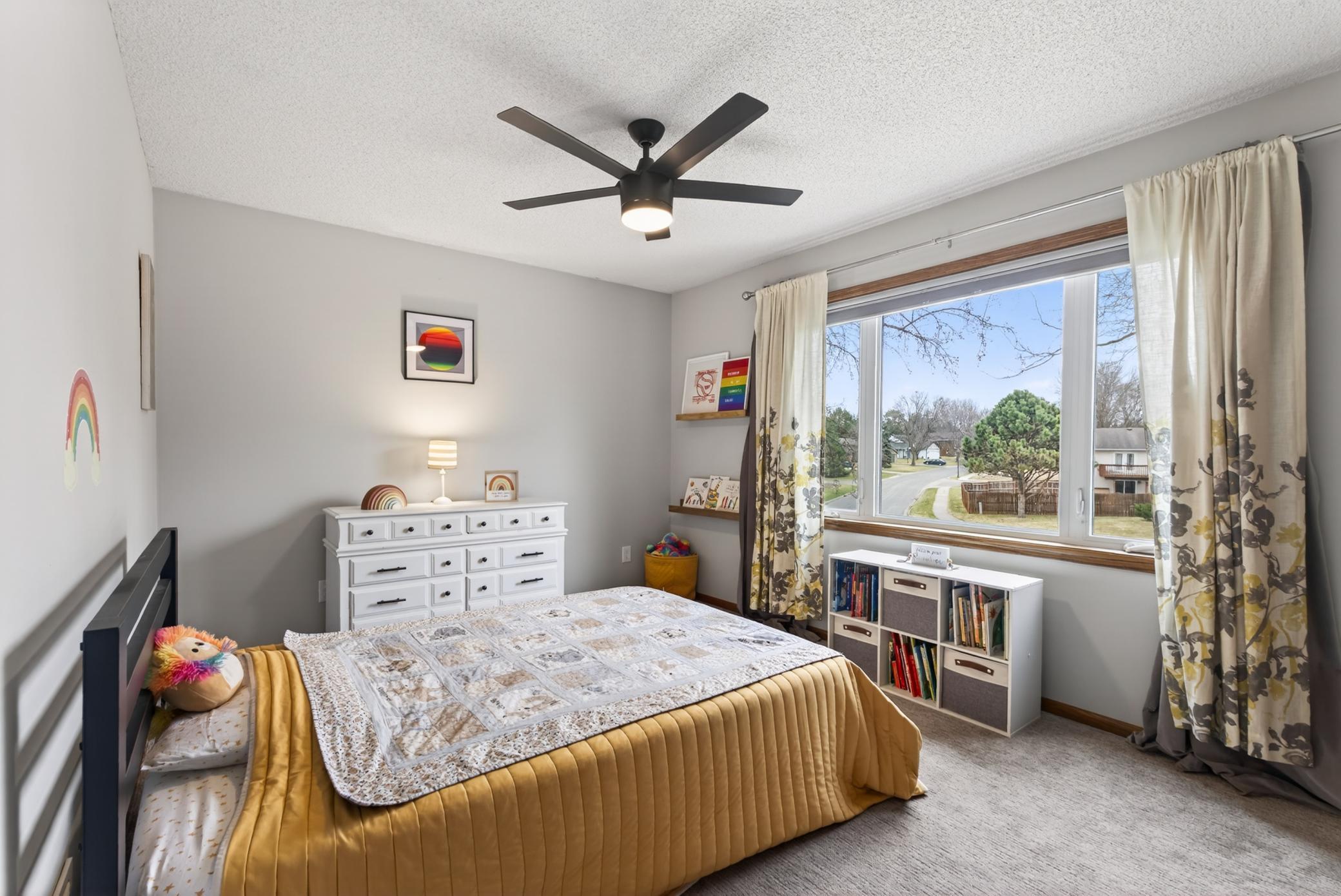 2nd upper level bedroom with large windows and ceiling fan.