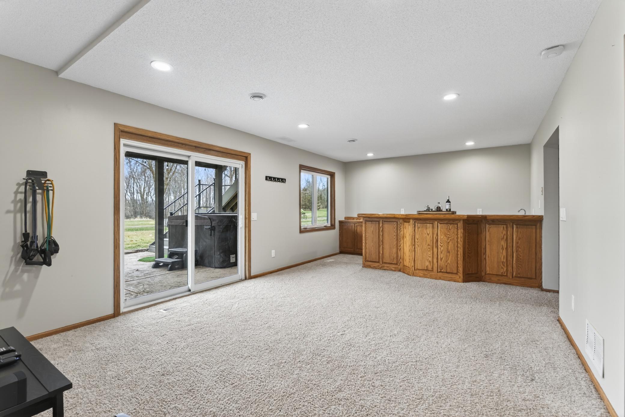 Expansive basement recreation room with wet bar.