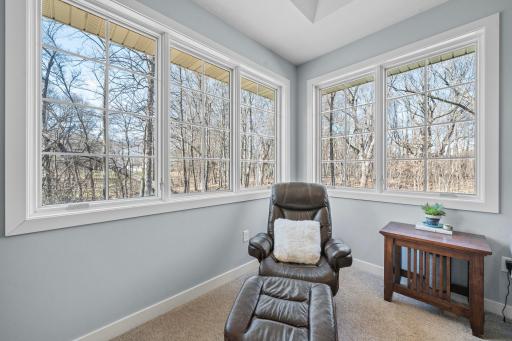 The spacious master suite is filled with natural light from large windows that frame a peaceful, private setting.