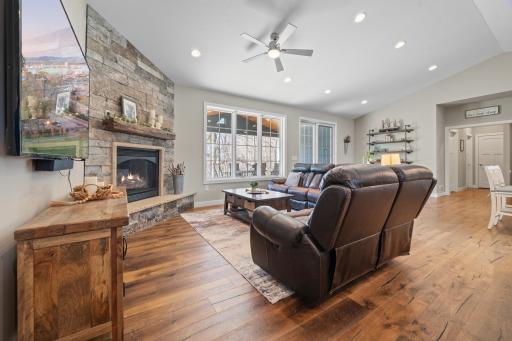 Enjoy the comfort of the gas fireplace as natural light pours through large windows, showcasing tranquil views in this open-concept space.
