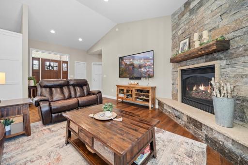 A cozy gas fireplace anchors the open floorplan, while sunlit windows invite the beauty of nature inside.