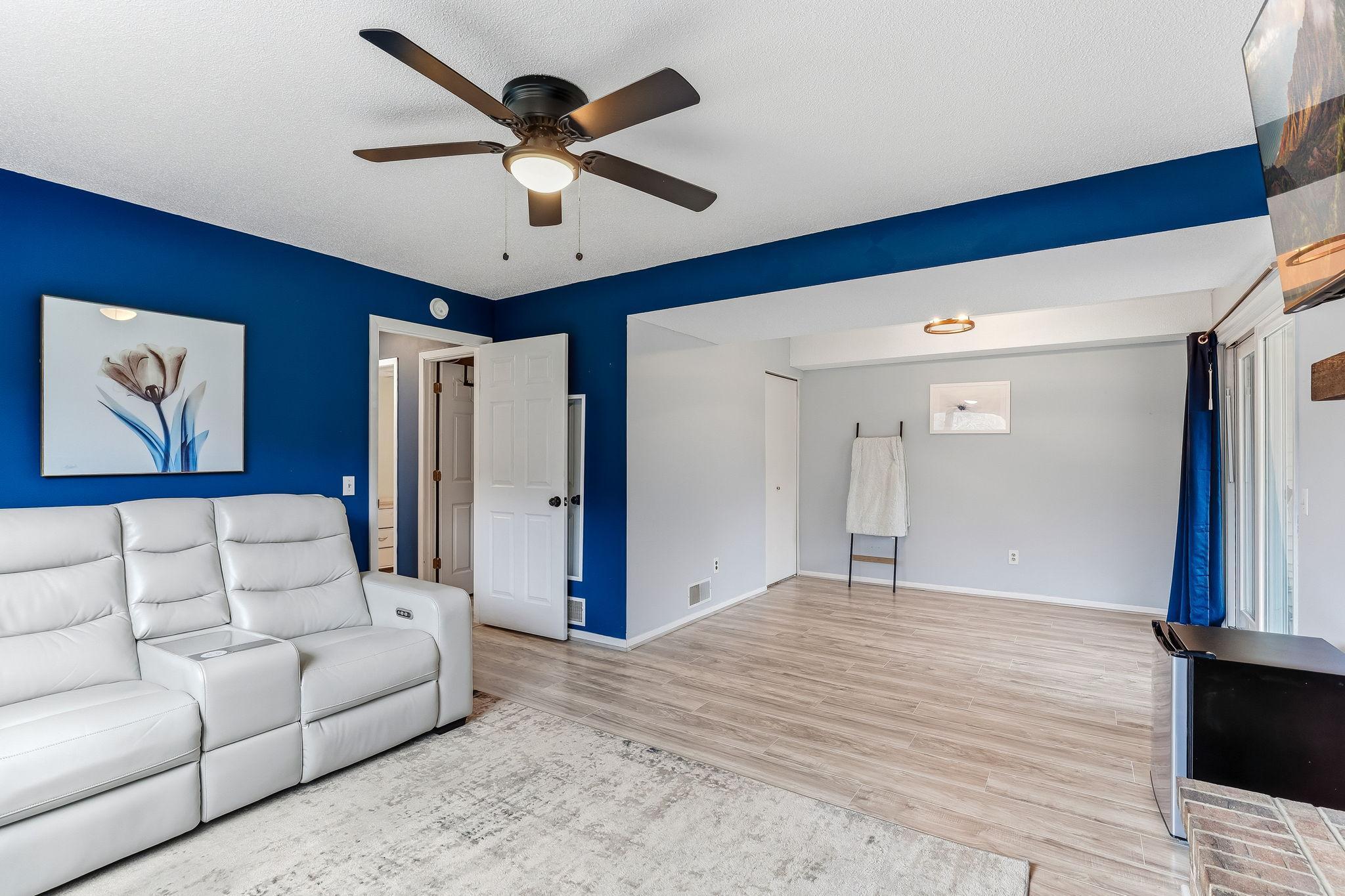 Open lower-level layout with defined living area and additional flex space, ideal for media, office, or recreation.