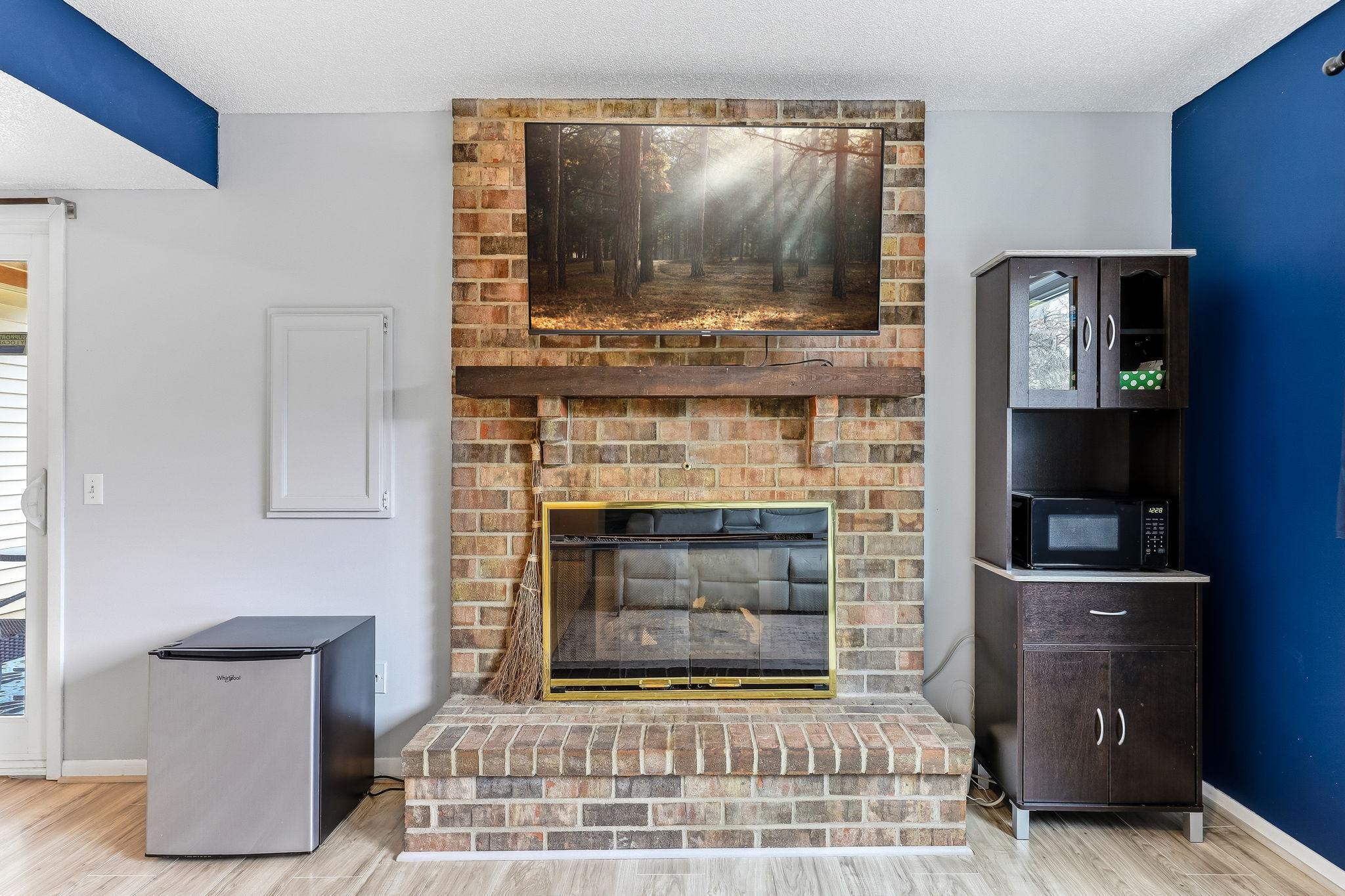 Brick fireplace with mantle serves as a focal point, adding warmth and character to the space.