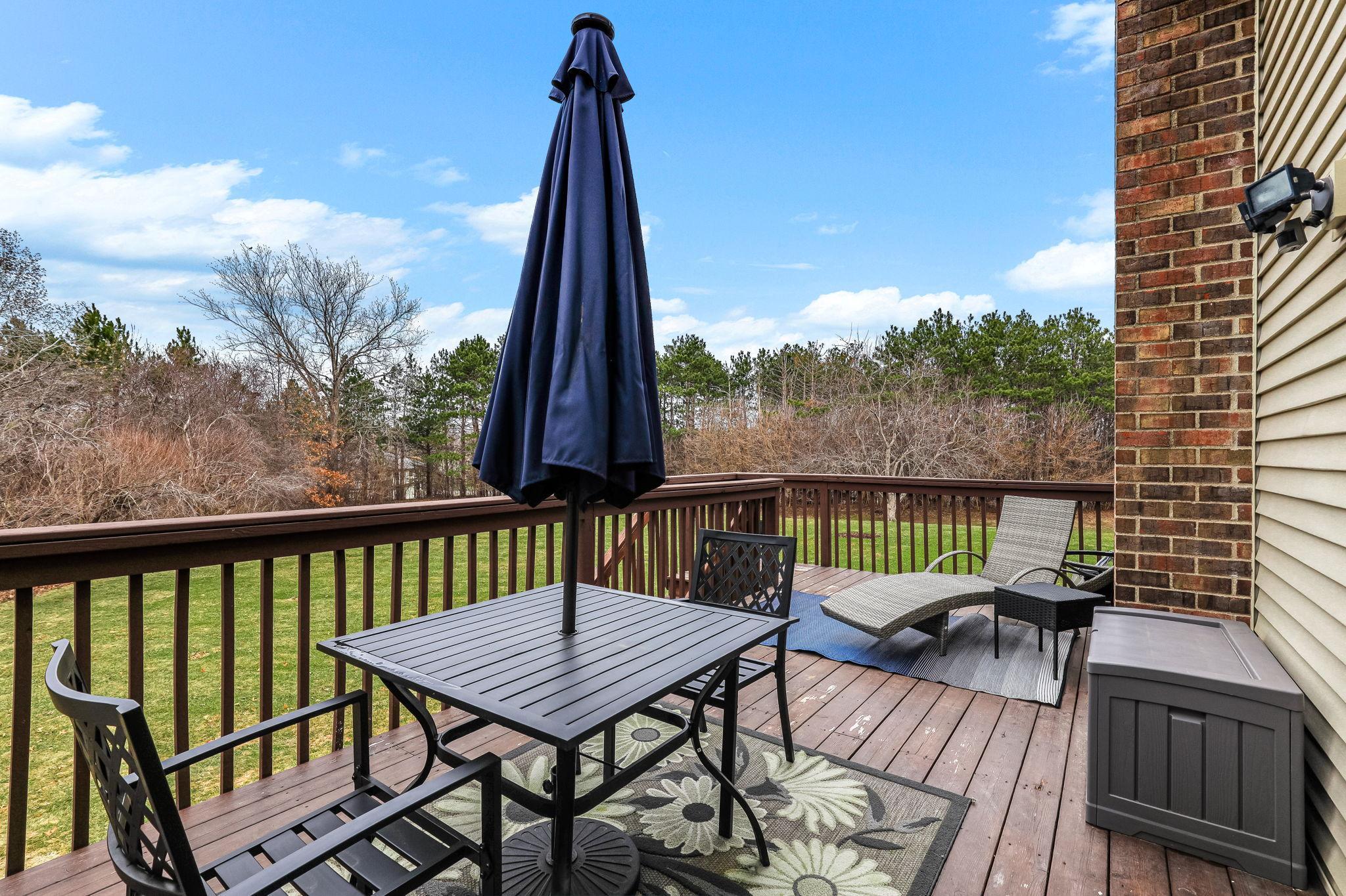 Private deck overlooking open green space, offering a peaceful outdoor setting ideal for relaxing or entertaining.