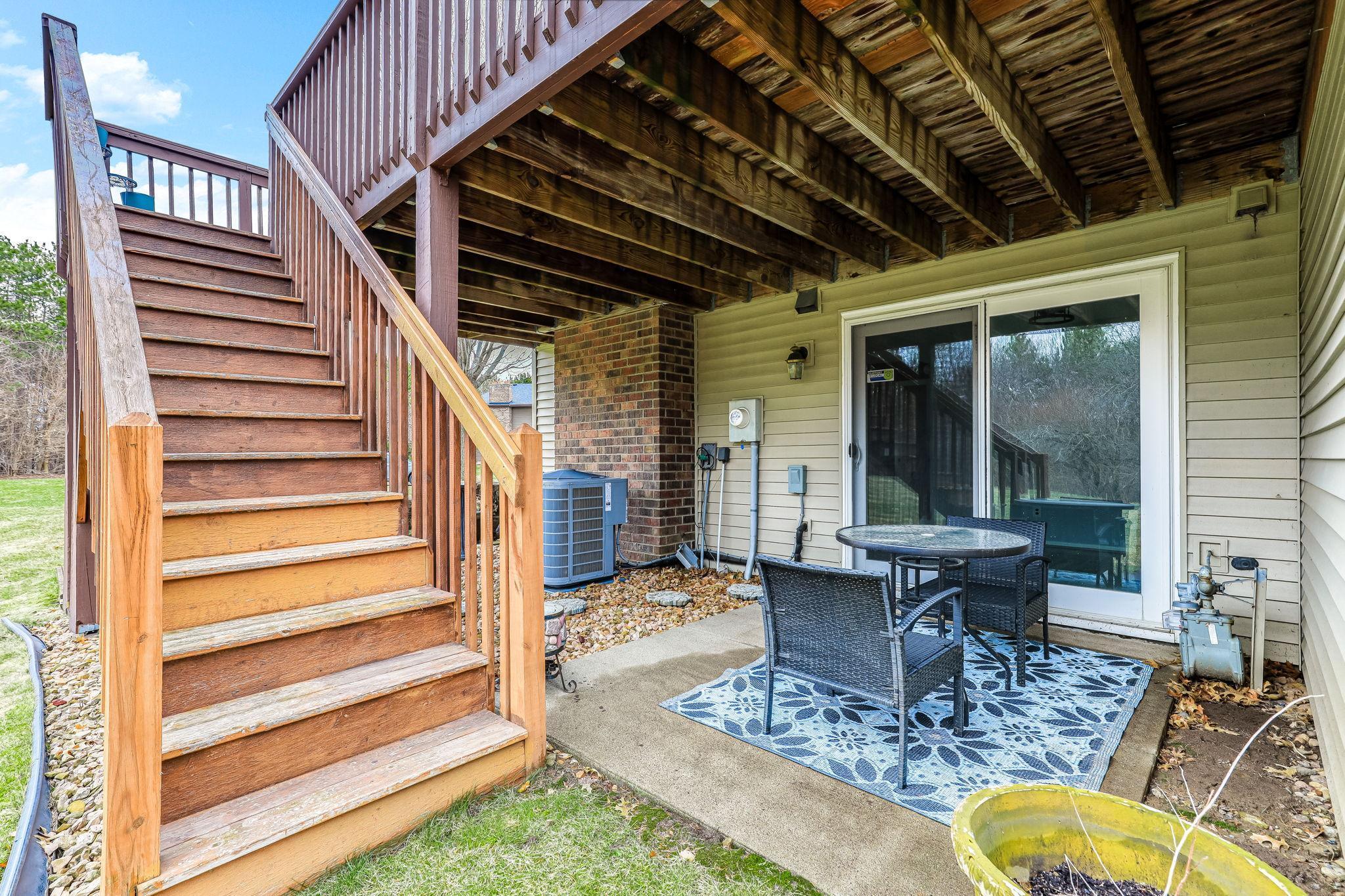 Patio positioned beneath the deck with direct access to both levels, creating a layered outdoor living setup.