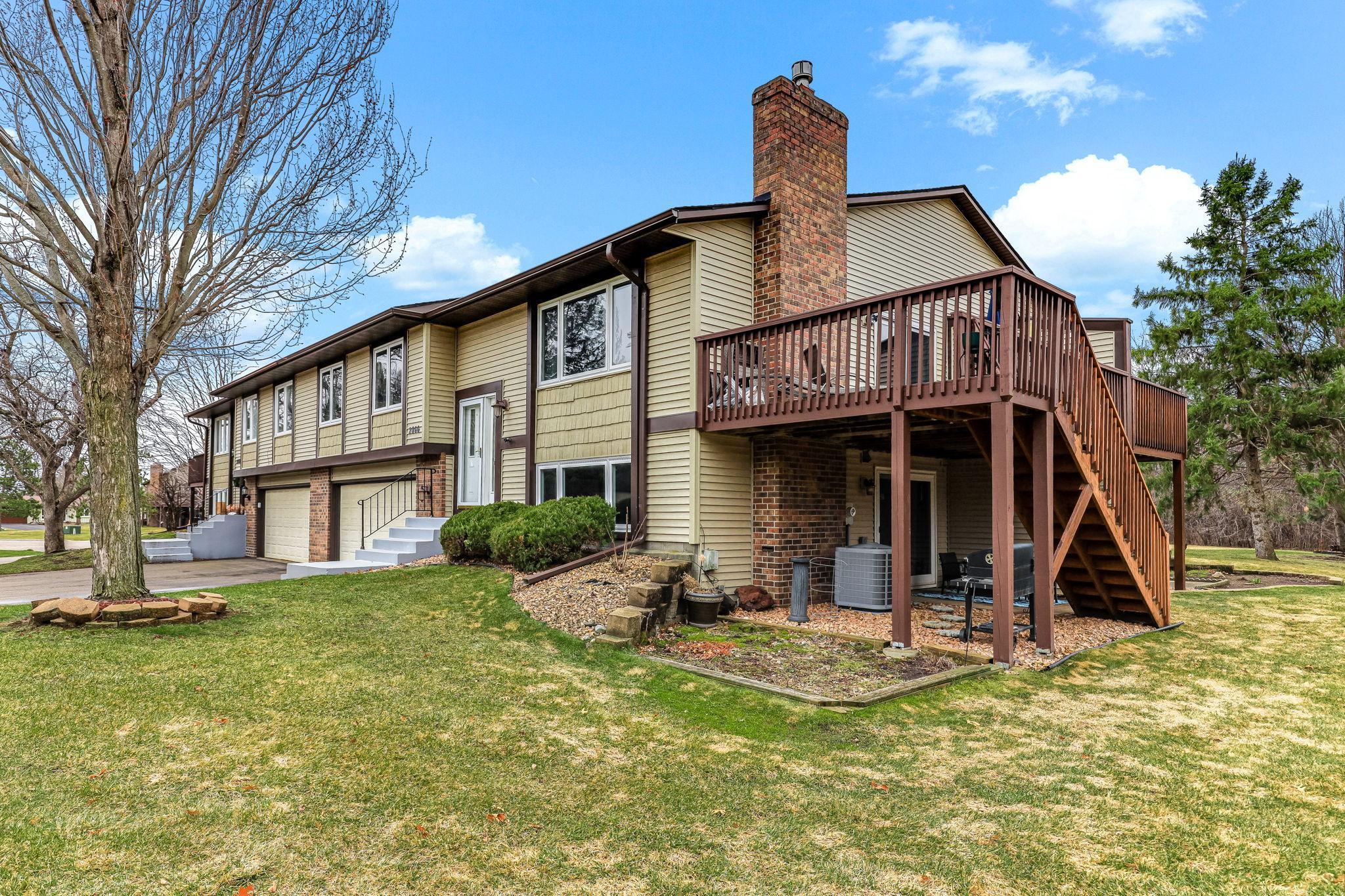 Rear exterior showcasing elevated deck, walkout lower level, and generous yard space.