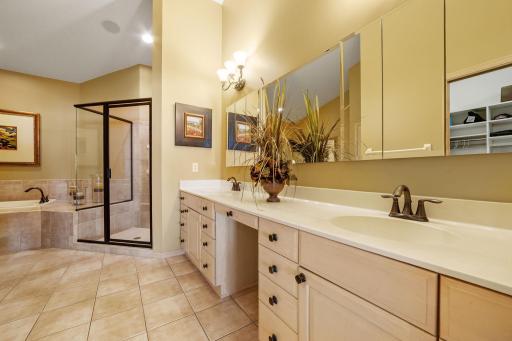 Master Bathroom features large vanity cabinet w/ dual sinks and additional make-up counter, linen closet, ceramic tile flooring and pocket door access