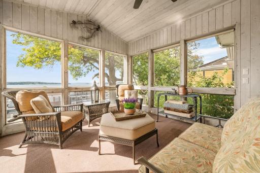 Screened-in porch features wood paneled walls and ceiling + ceiling fan