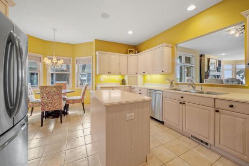 Maple cabinetry features raised panel doors, roll-out storage, under cabinet accent lighting, appliance garage, full height pantry, workstation and center island