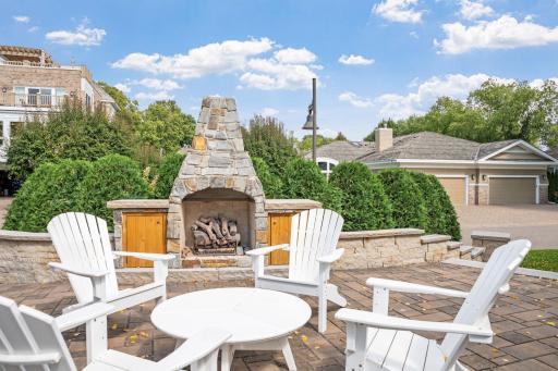 Shared patio area offers a stone wrapped wood burning fireplace, spacious sitting area with/ pergolas surrounded by stone retaining walls and mulched gardens