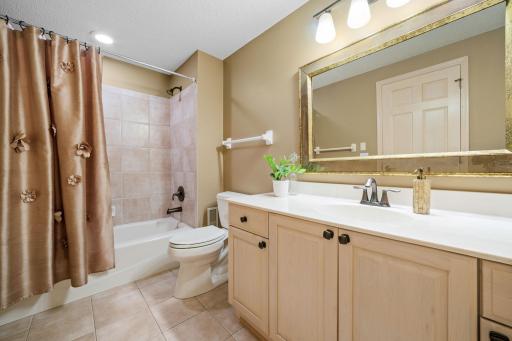 Lower Level Full Bathroom features maple vanity cabinet and ceramic tile tub surround and flooring.