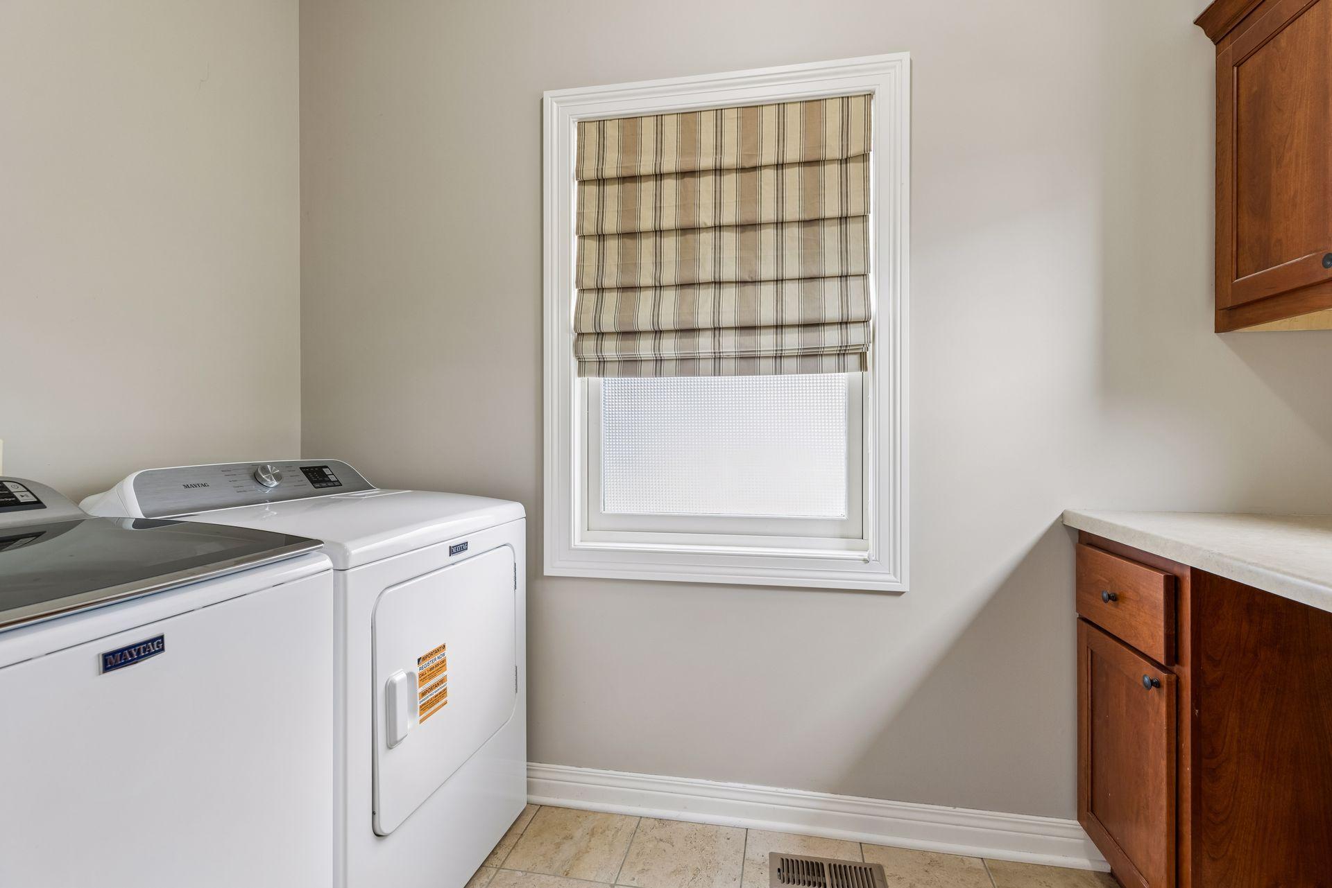 Main level laundry with folding countertop and storage.