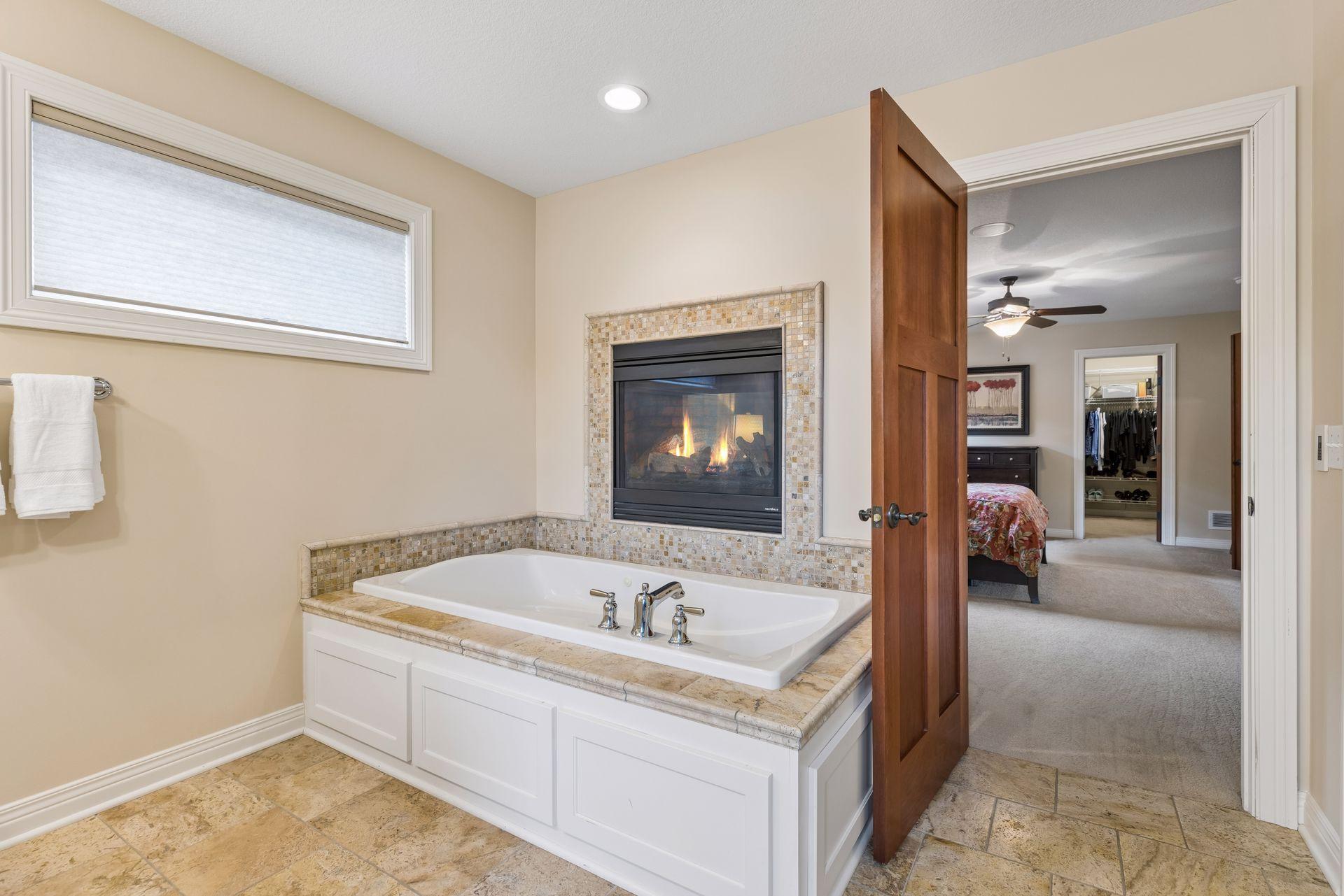 Luxurious two-sided gas fireplace shared between bedroom and bathroom.