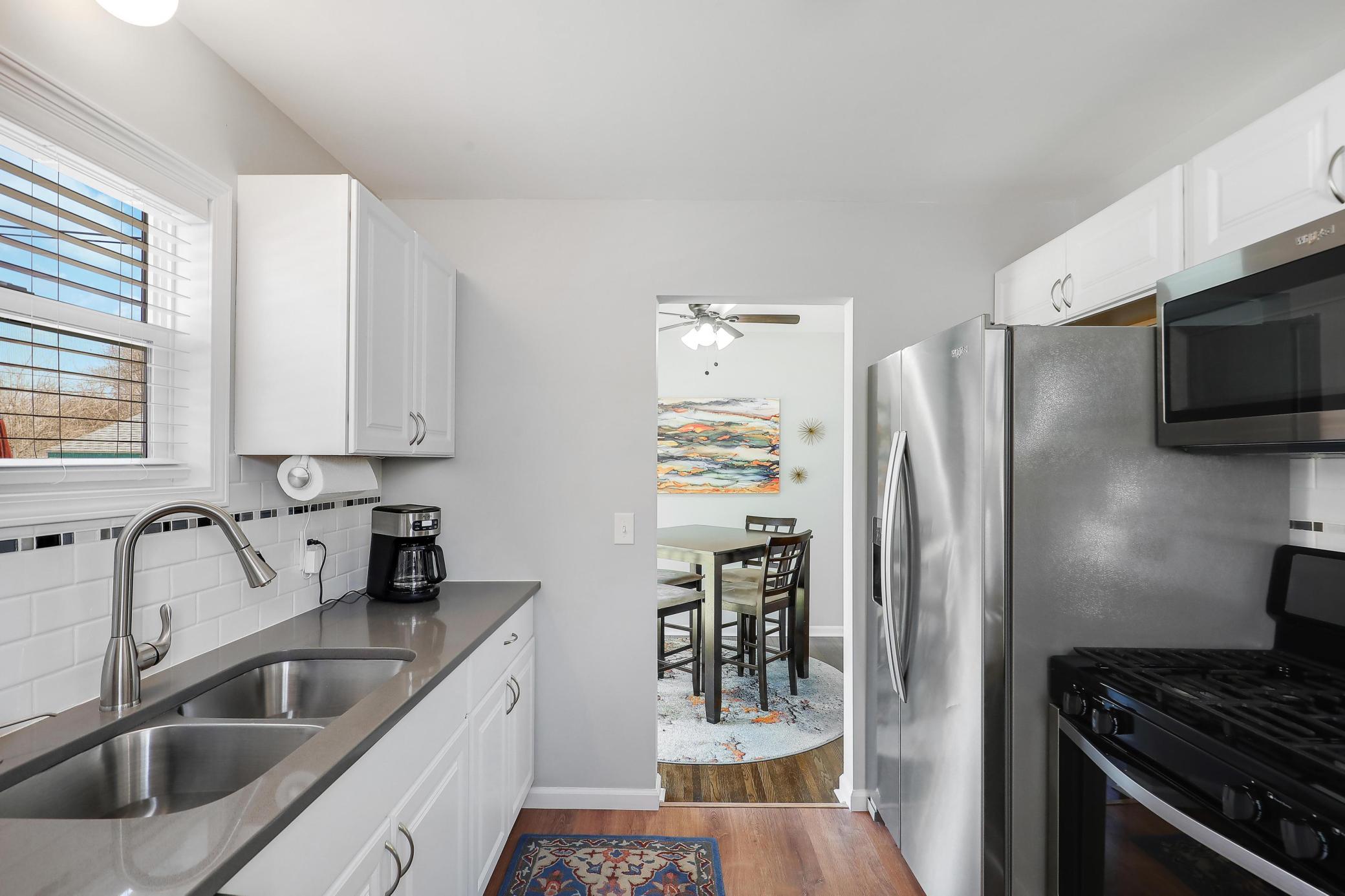 Renovated kitchen with views to the backyard, white cabinetry, stainless appliances including a GAS oven!