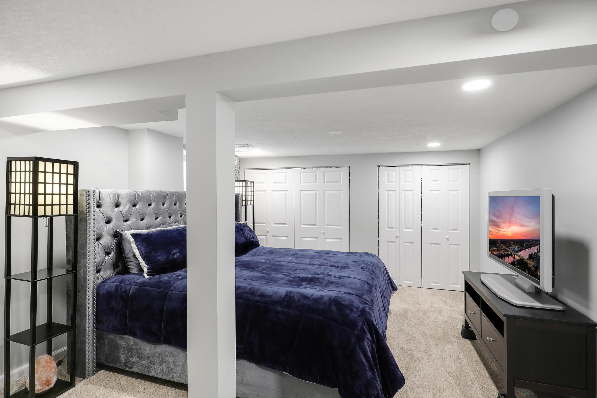 Lower level primary bedroom ensuite with a wall of closets! Recessed lighting and a egress window certainly does not feel like a basement.