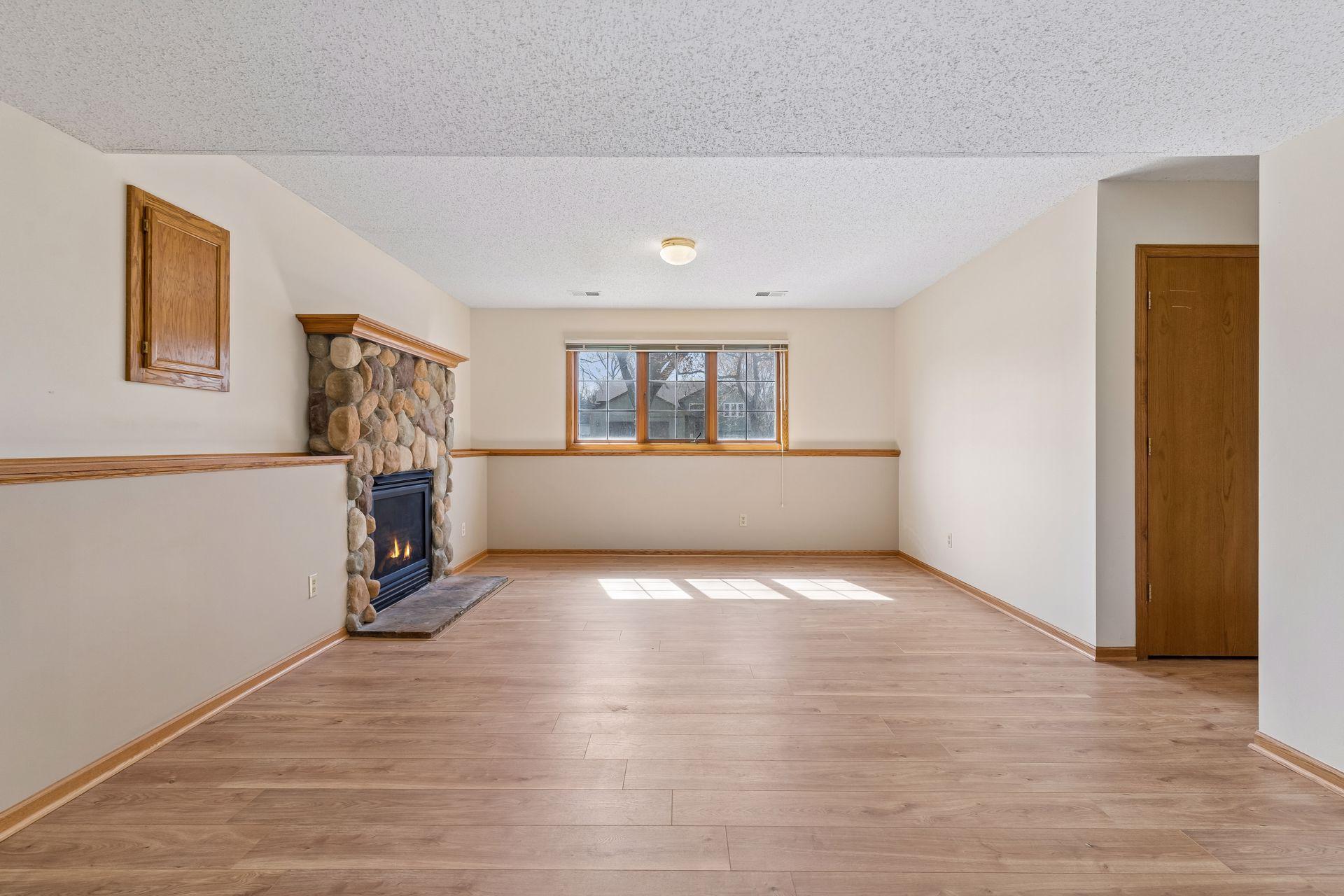 Lower level family room features a 2nd cozy fireplace with stone surround!