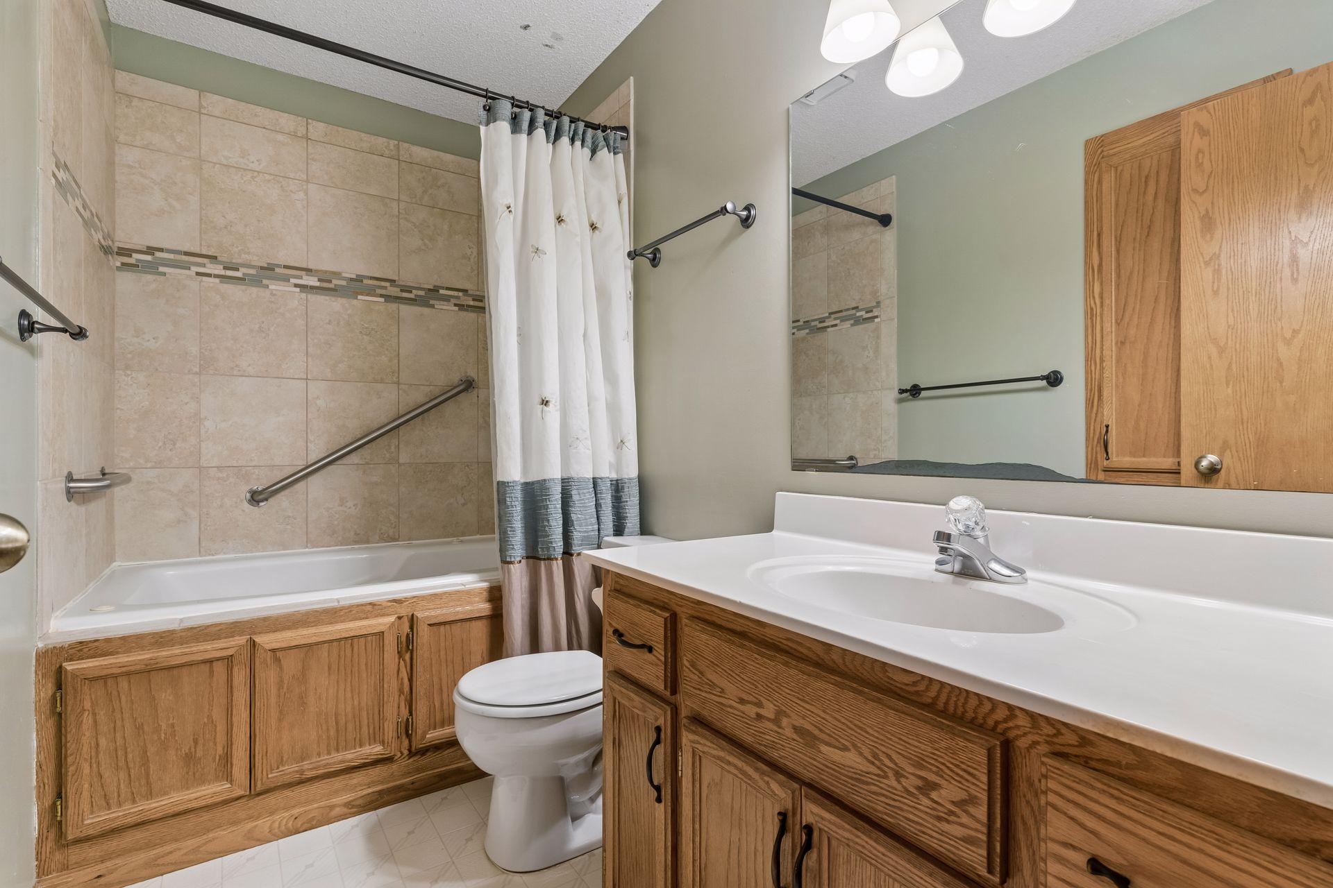 Main level bath with ceramic bath surround and grab bars