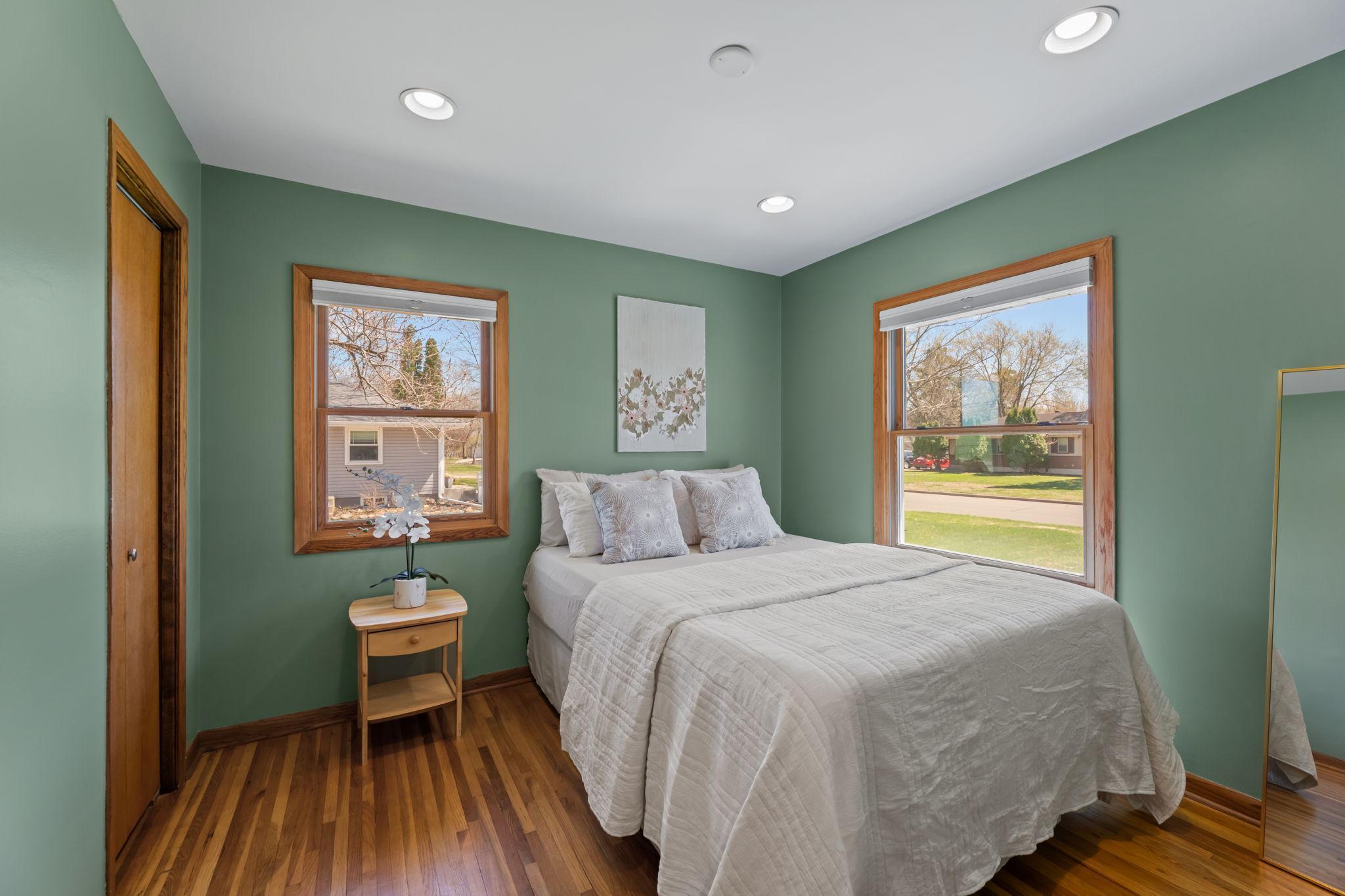 The main-level second bedroom is enhanced by beautiful hardwood floors, creating a warm and inviting space.