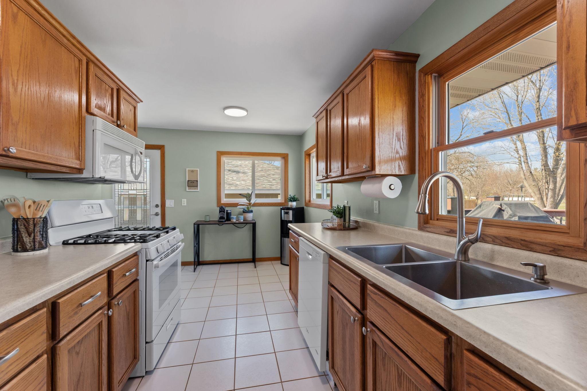 The kitchen is well-equipped with a gas range, new refrigerator (2023), microwave, and dishwasher, combining style and functionality for everyday living and entertaining.