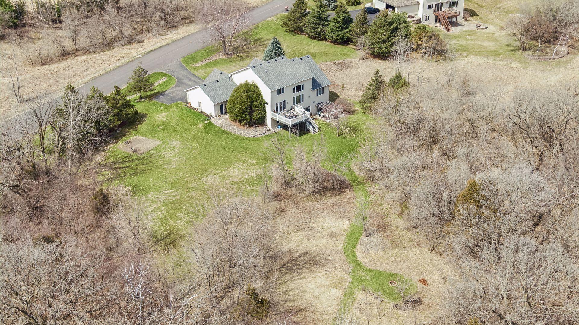 Expansive yard with room to enjoy, surrounded by mature trees and natural landscape.