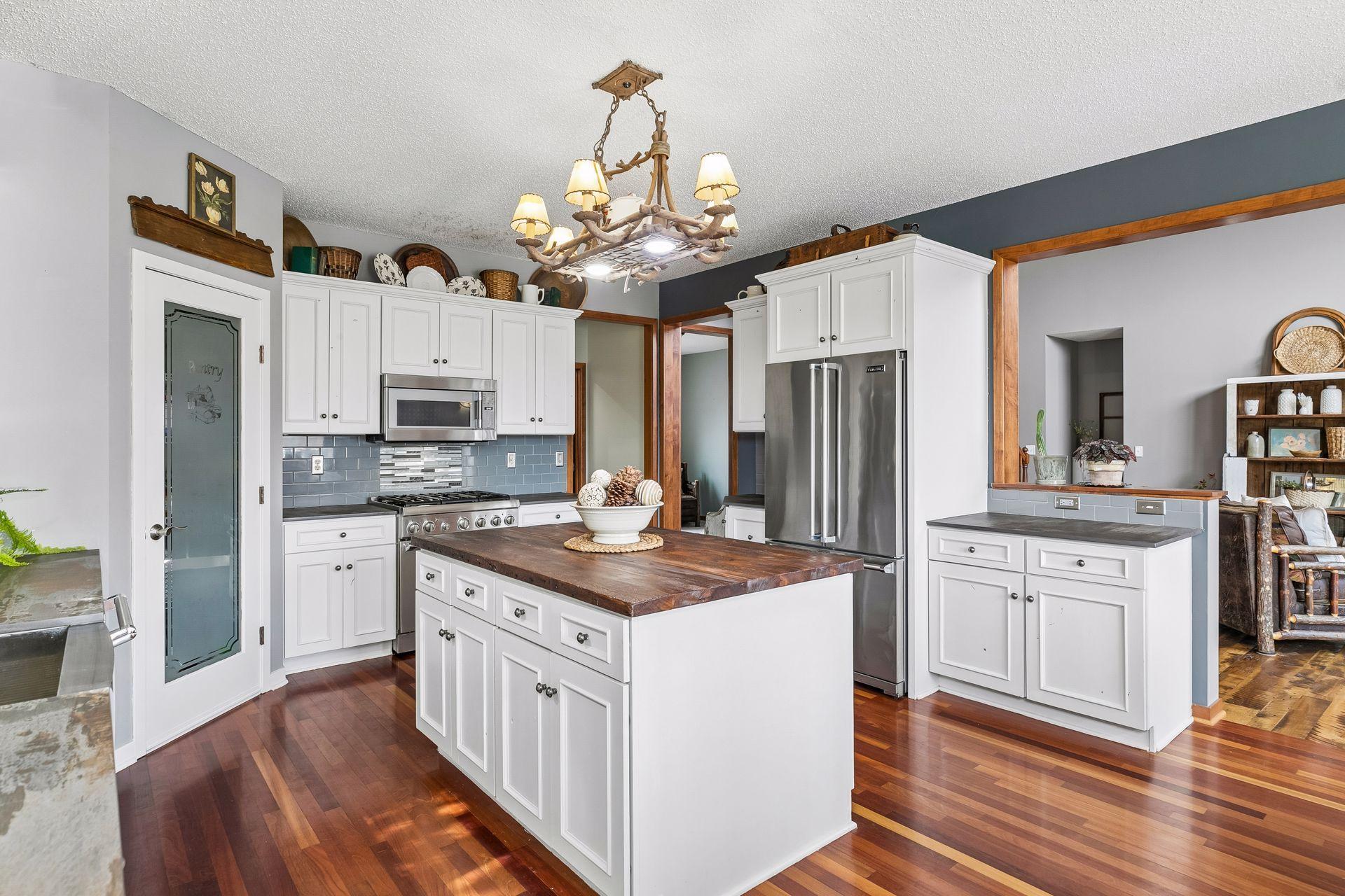 Kitchen with large center island, Dekton countertops, tile backsplash, and updated stainless steel appliances (2018).