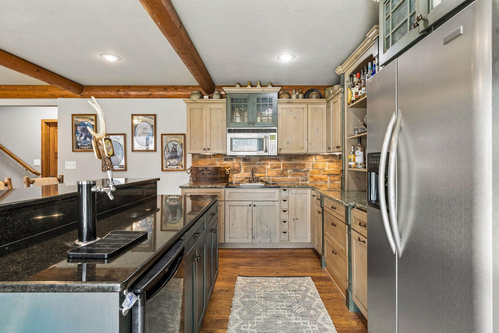 Lower level wet bar with granite countertops, sink, refrigerator, and dishwasher—perfect for entertaining.