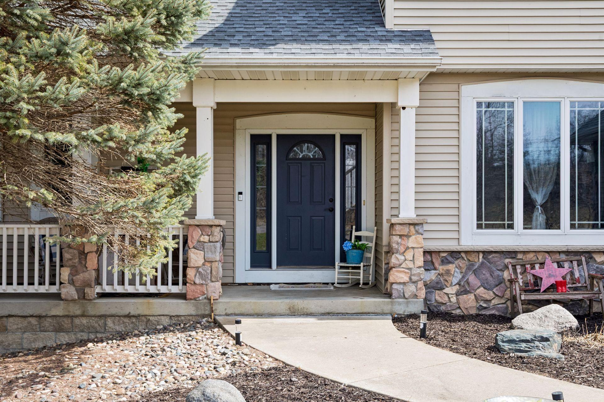 Inviting front entry with covered porch and stone accents.