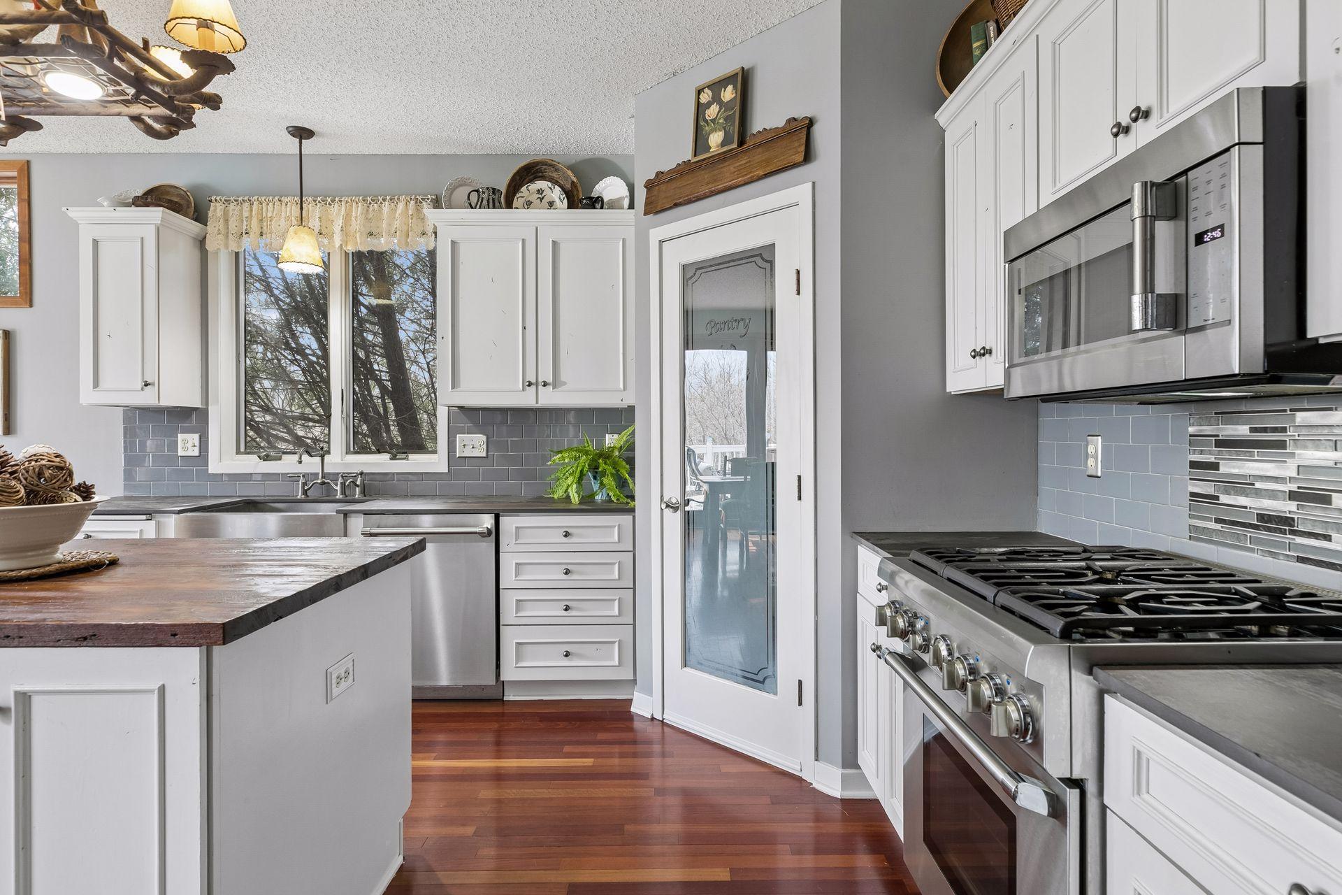 Gas range with tile backsplash and plenty of cabinet storage.