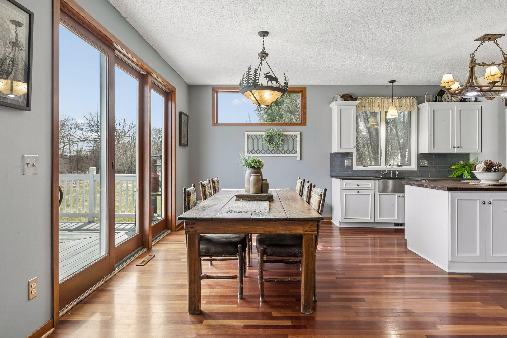 Dining area with cherry wood floors and access to the deck overlooking the backyard.