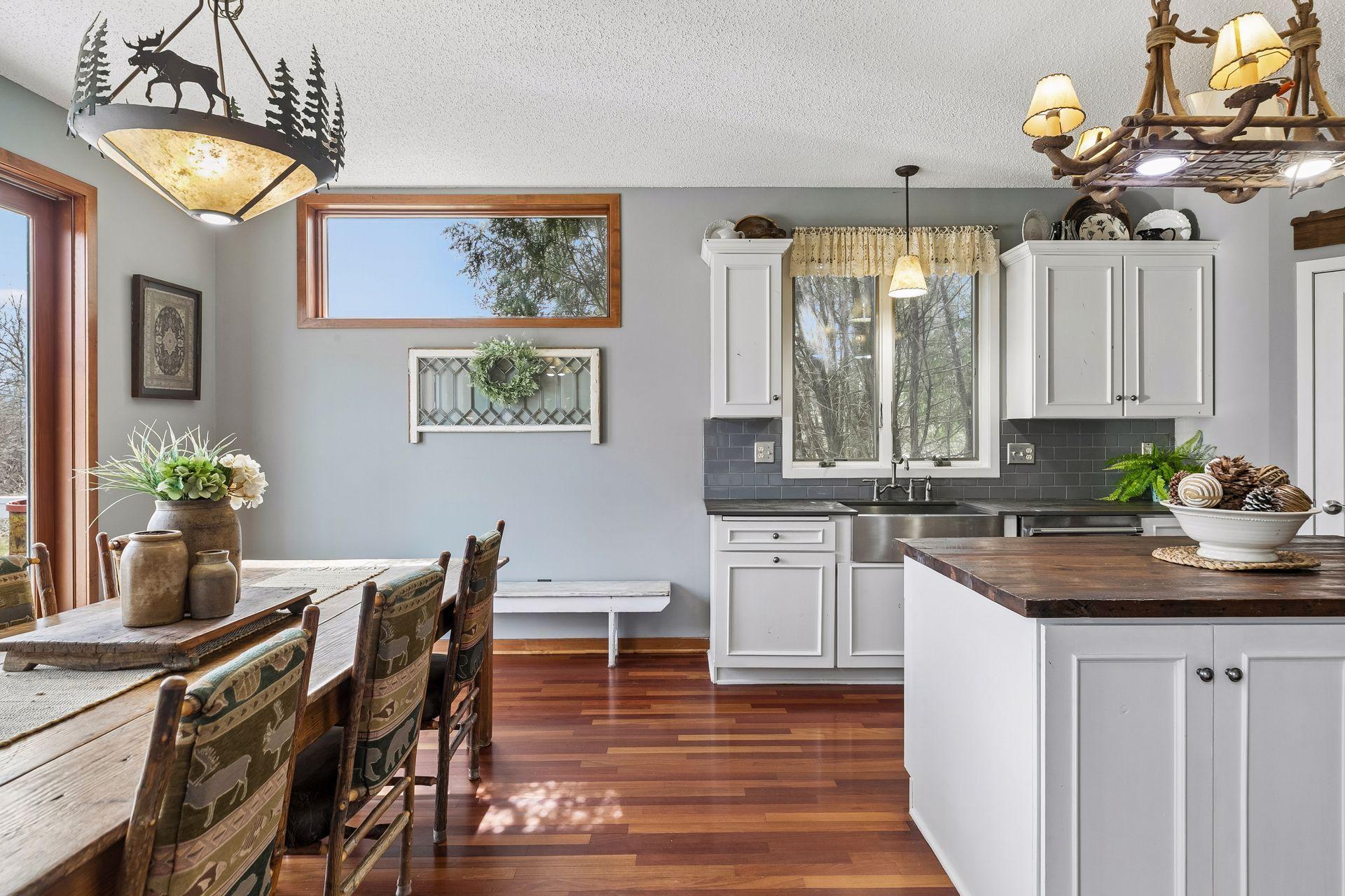 Farmhouse-style sink with window views and tile backsplash.