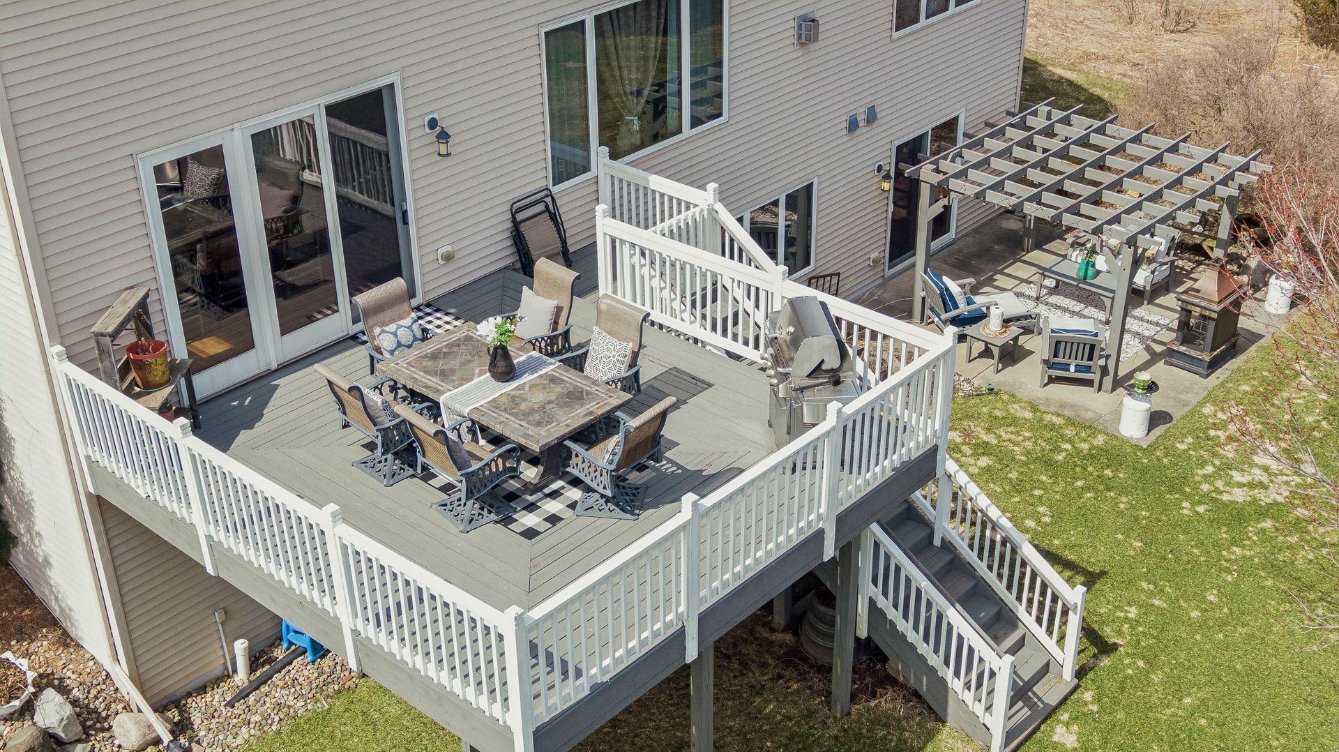 Deck with plenty of space for seating and grilling, overlooking the yard and patio below.