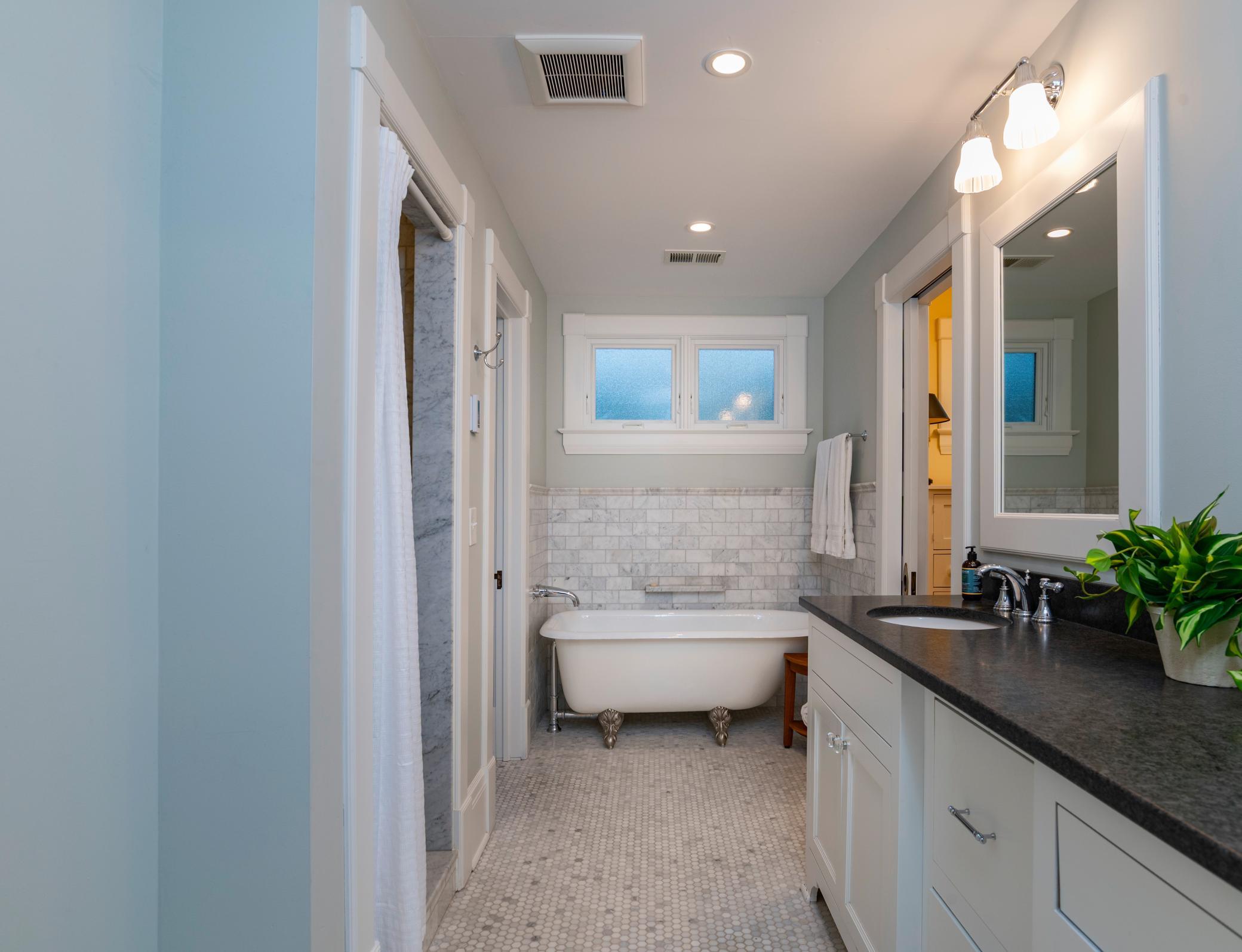 A private four piece bathroom with period correct clawfoot tub and walk-in stall shower.
