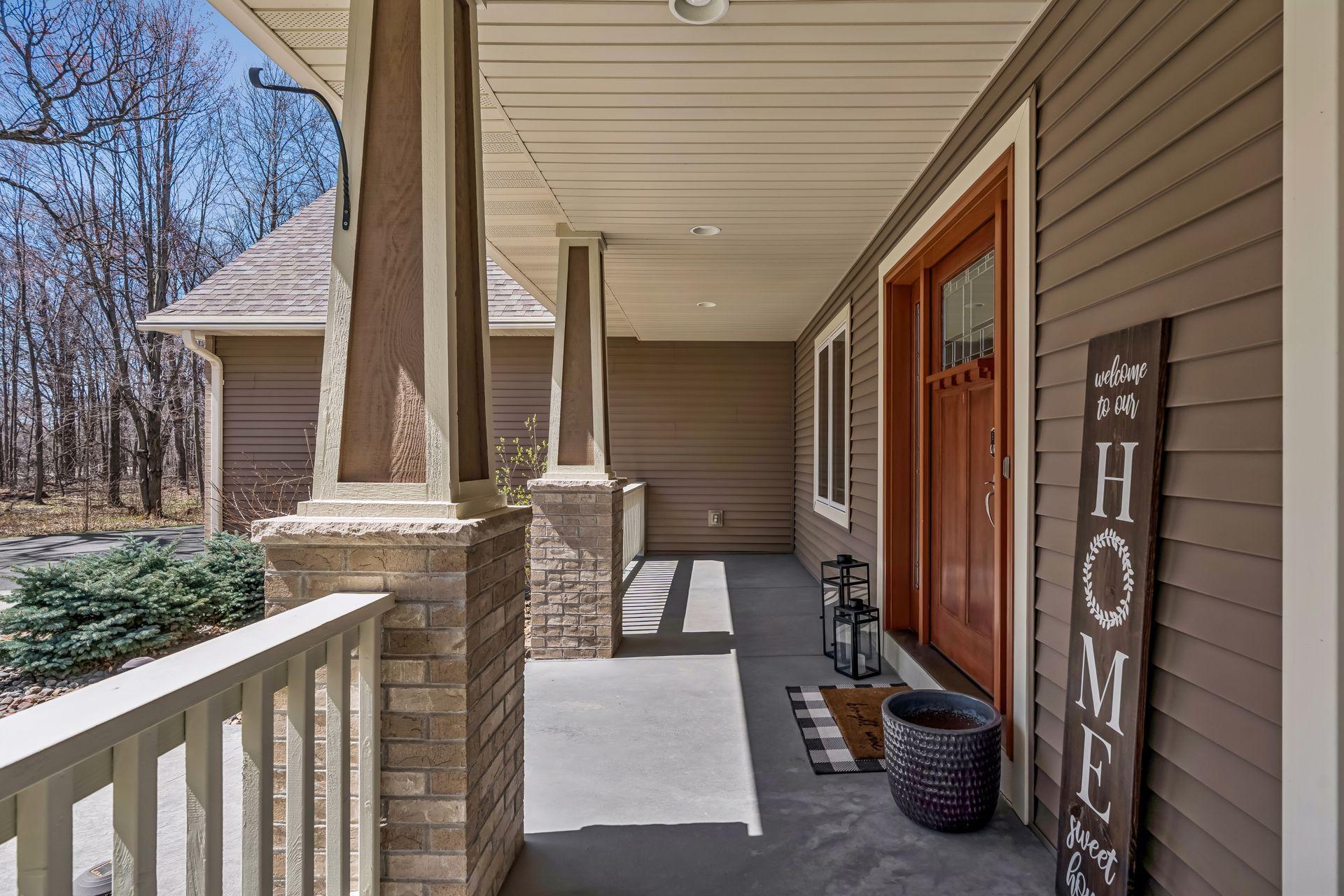 Large concrete front porch for hanging flower baskets and entry patio pots.