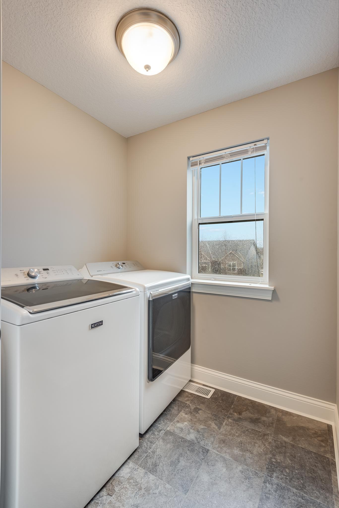 Upper level laundry with recessed storage area (not shown) and window